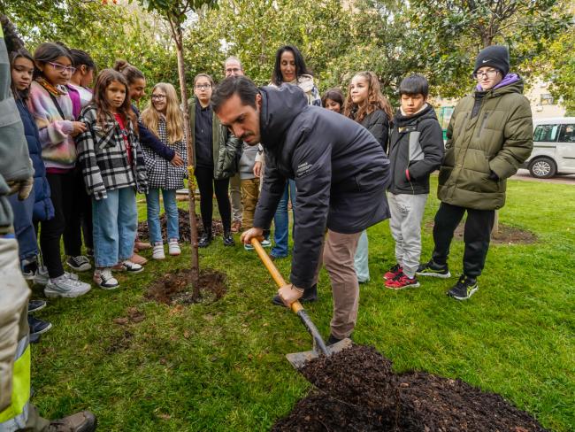El alcalde, Alejandro Navarro Prieto, la concejala de Medio Ambiente, Esperanza Fernández, y alumnos del CEIP Buen Gobernador plantado el madroño 45 del Parque Constitución