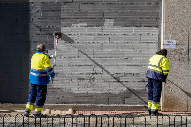 Operarios quitando grafitis de una fachada