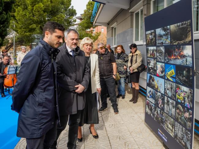 El alcalde de Torrejón, el ministro consejero de la embajada de Ucrania en España y la representante de los ucranianos en Torrejón de Ardoz observando uno de los panales con imágenes sobre la guerra de Ucrania instalado en el Centro Cultural El Parque
