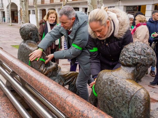 El concejal de Bienestar, Educación e Inmigración, Rubén Martínez, y la edil de Sanidad, Carla Picazo, colocando brazaletes verdes en las estatuas de la Plaza Mayor